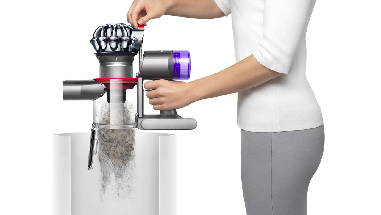 Femme vidant un aspirateur Dyson V8